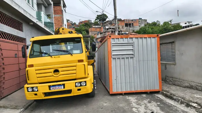 Manobra de carregamento junto a container em via estreita